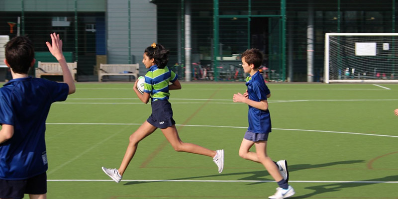 Students running outside on the astroturf